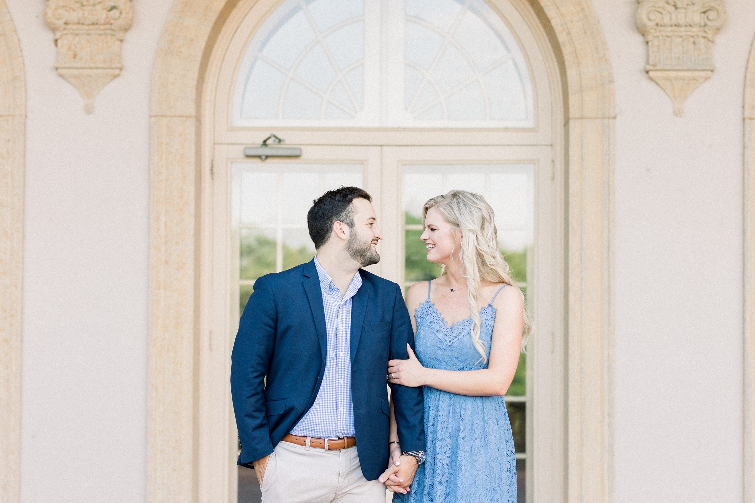Gorgeous partners, holding hands, as they pose for engagement photos.